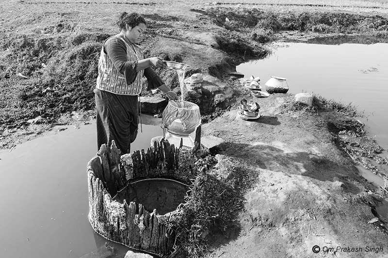 Procuring drinking water from an old damaged Kukuru Daarhi in Khunti district, Jharkhand, India